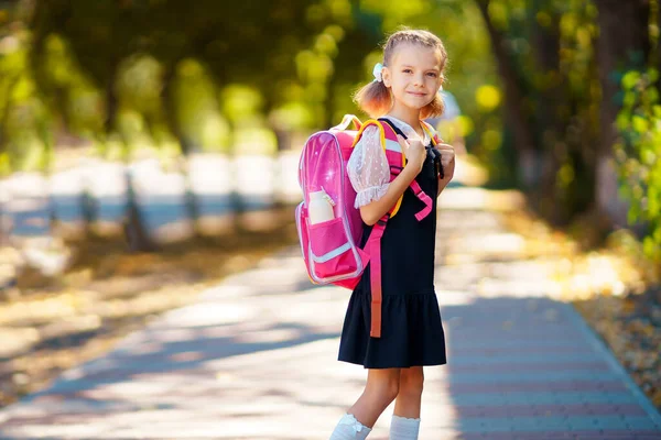 Hermosa niña con mochila caminando en el parque listo para volver a la escuela, caída al aire libre, concepto de educación —  Fotos de Stock