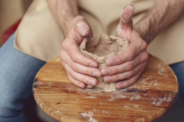 The master creates a white clay product. The masters hands close-up sculpt a clay product using a potter s wheel. The potter teaches his apprentice mastery