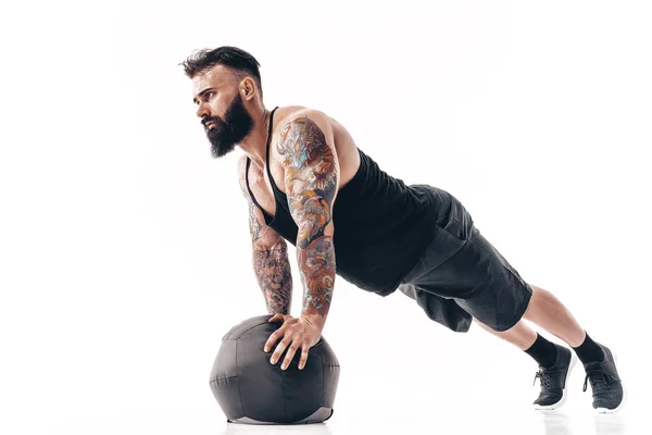 Ένας καυκάσιος που ασκεί βάρη γυμναστικής Ιατρική Ball push ups ασκήσεις σε στούντιο απομονωμένα σε λευκό φόντο — Φωτογραφία Αρχείου