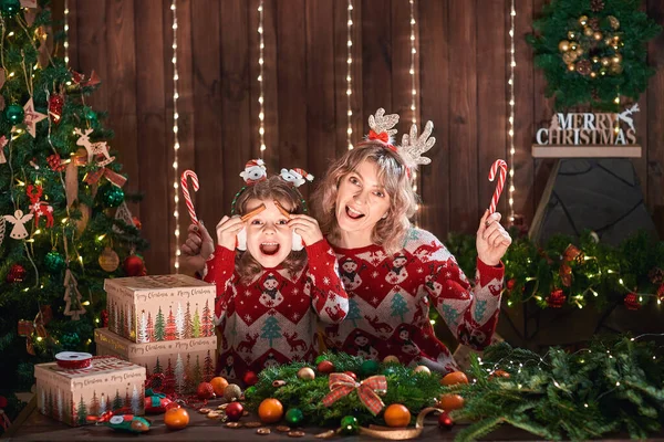 Mãe com criança menina perto da árvore de natal. feriados de ano novo. família feliz. mulher com filha se divertindo e sorrindo, fazendo rostos — Fotografia de Stock