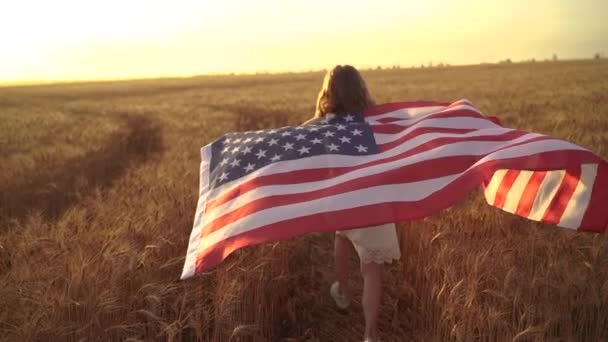 Girl in white dress wearing an American flag while running in a beautiful wheat field — Stock Video