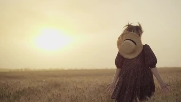 Donna in abito stampa animalier, cappello di paglia davanti al sole in mezzo al campo di grano con piacere, godendo le vacanze estive — Video Stock
