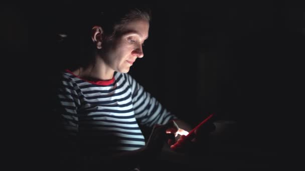 女性はSMSを送信,ニュースを読む,チャット,夜屋外で電話でネットサーフィン — ストック動画