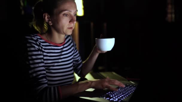 Enferma mujer de negocios que trabaja por la noche en un ordenador portátil y beber cofee, al aire libre — Vídeo de stock