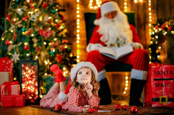 Καλά Χριστούγεννα, Άγιε Βασίλη και κοριτσάκι τη νύχτα στο χριστουγεννιάτικο δέντρο. — Φωτογραφία Αρχείου