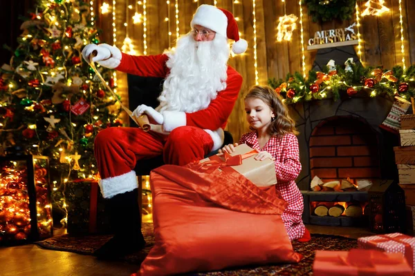 Wesołych Świąt, Świętego Mikołaja i małej dziewczynki w nocy na choince — Zdjęcie stockowe