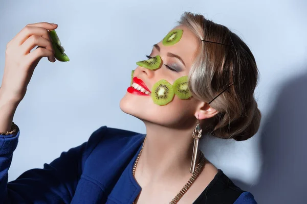 Foto fashion wanita berpose dengan irisan kiwi di wajahnya — Stok Foto