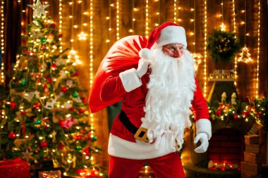 Noel Baba çantasında hediyeler taşıyor.