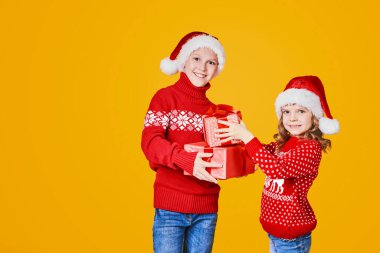 Kırmızı hediye kutularını tutan mutlu çocuklar.