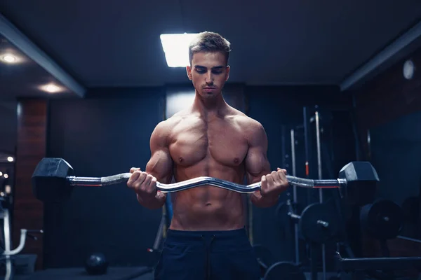 Młody człowiek robi ciężkie ćwiczenia na biceps — Zdjęcie stockowe