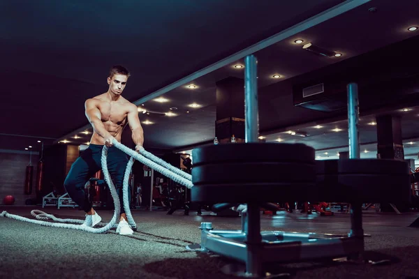 Hombre de fitness haciendo ejercicio con cuerdas de batalla en el gimnasio — Foto de Stock