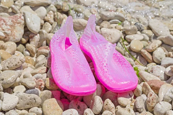 plastic snorkeling shoes on stones near the sea