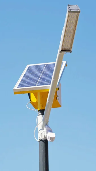 Street Light powered by a solar panel with a battery against blue sky