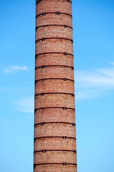 old brick factory chimney against sky