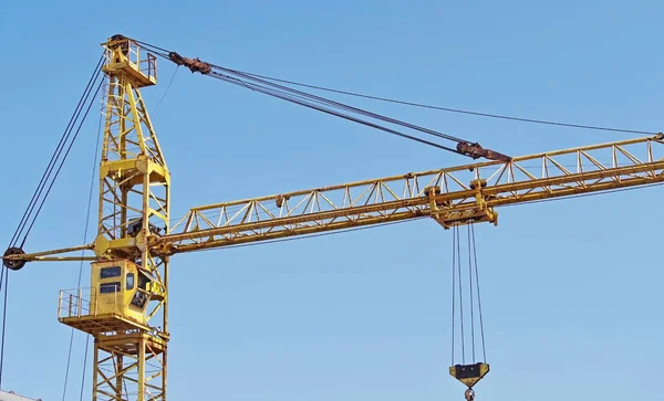 yellow construction crane tower on background of evening blue sky