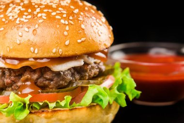 Burger bir pirzola, salata, sebze ve sos lu yeşillik ile koyu bir arka plan üzerinde