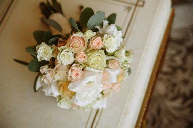 Nazik tonlarda güller ile bir düğün buketi.