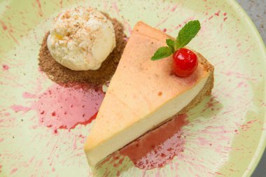 Vişneli cheesecake. Dondurmalı cheesecake. Soslu sarı tabakta cheesecake