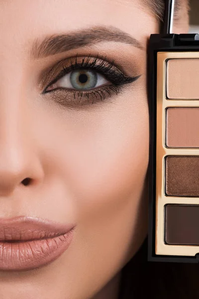 Makeup. Girl with makeup and eyeshadow palette. Smokey eyes