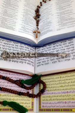 İncil, Kuran ve Tevrat. Dinlerarası diyalog kavramı. Hristiyanlık, İslam ve Musevilik, üç tek tanrılı din. Dini semboller: Hristiyan haçı, yad, tespih..