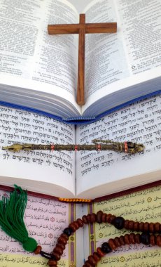 İncil, Kuran ve Tevrat. Dinlerarası diyalog kavramı. Hristiyanlık, İslam ve Musevilik, üç tek tanrılı din. Dini semboller: Hristiyan haçı, yad, tespih..