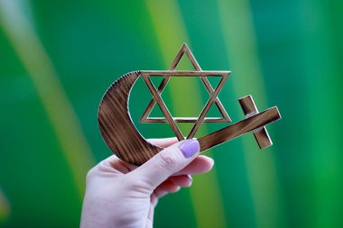 Elinde dini semboller var. Yahudi Davut Yıldızı, Müslüman yıldız ve Hilal, Hıristiyan Haçı. Din, dinler arası ve dinler arası diyalog kavramı.