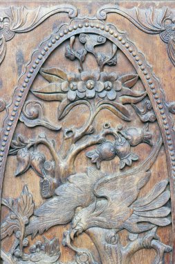 Tan Hoa Kilisesi. Heykelleri olan ahşap kapı. Çiçekler ve kuş..