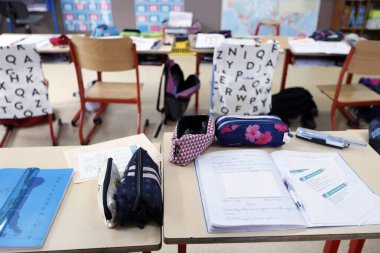 İlkokul. Masada kitap ve kalemler var. c France.