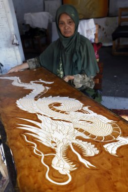 Batik Prodüksiyon. Kadın ejderha tasarımı için sıcak balmumu kullanıyor. Yogyakarta. Endonezya.