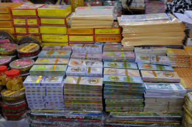 Tapınaklar için Budist ve Taoist adaklar satan bir dükkan. Cehennem banknotları ve diğer kağıt parçaları. Rengi. Vietnam.