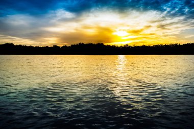 Günbatımı üzerinde nehir ve yapısı orman