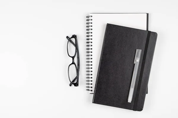 Pohled shora na kancelářský stůl s notebooky pera a brýle — Stock fotografie