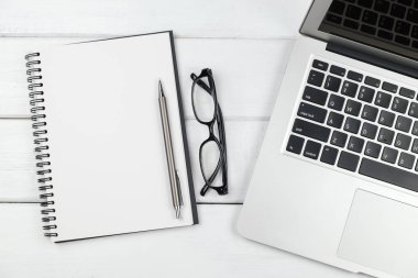 Beyaz ahşap arka plandaki dizüstü bilgisayarın üst görünümü