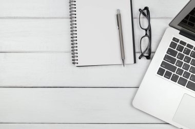 Beyaz ahşap arka plandaki dizüstü bilgisayarın üst görünümü