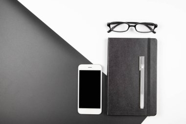 Dizüstü bilgisayar ve cep telefonu ile minimal ofis masası