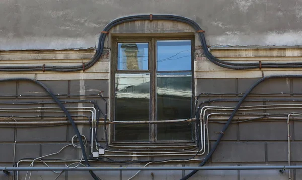 铺设电缆和电线的房子外墙上绕过窗口 — 图库照片