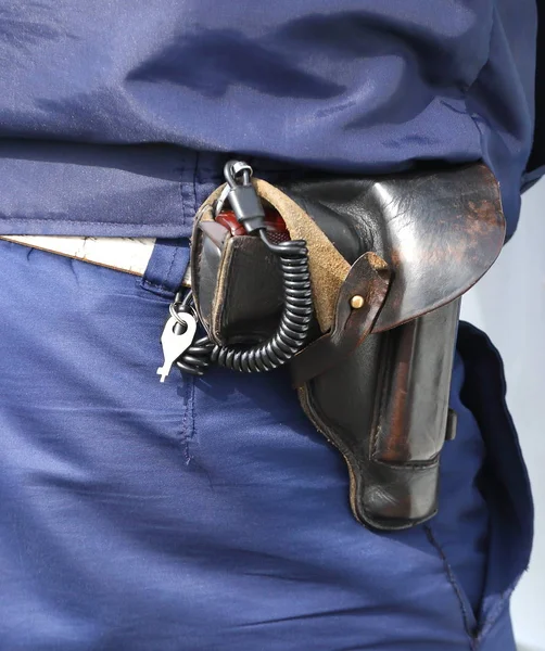 The gun in the holster on the belt of a policeman