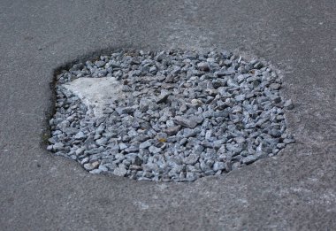 Yol yüzeyinde moloz kaplı çukur