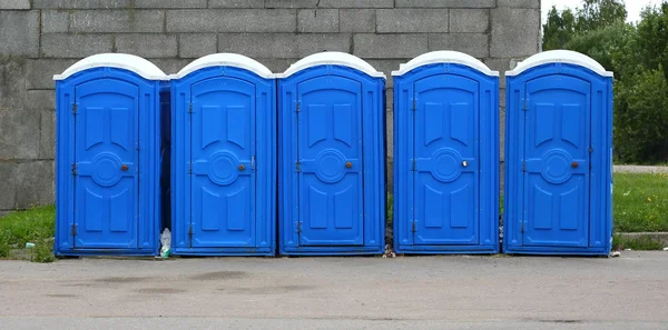 蓝色塑料紧凑型移动厕所靠近灰色墙 — 图库照片