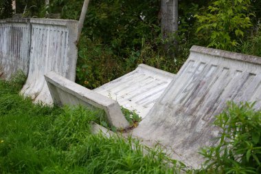 Yeşil çimde kırık beton çit düştü