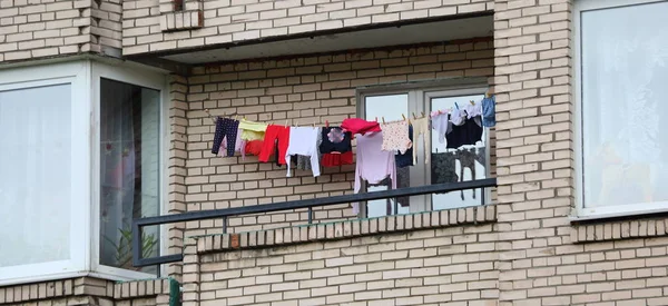 Washed clothes hung on a rope on the balcony of a house for drying