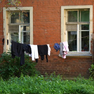 Bir evin bahçesinde yıkanmış giysilerin halat üzerinde kurutulan