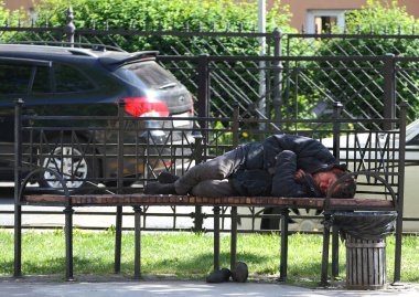 Evsiz bir serseri sokakta bir bankta uyuyor, Furshtadskaya ulitsa, Saint Petersburg, Rusya 2020