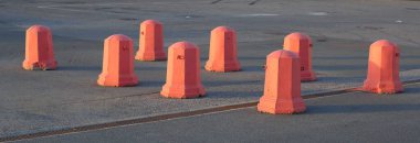 Otoparkta bir grup turuncu beton trafik duruyor.