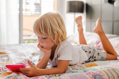 küçük çocuk odadaki telefona bakar