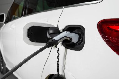 Elektrikli araba hortum bağlantısı, beyaz arabanın yan görüntüsü.