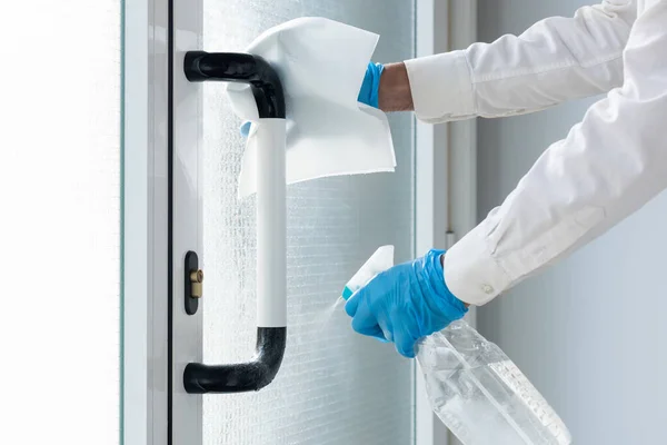Nitril eldivenli eller ve hidroterapi solüsyonlu sprey sprey ile kapı kolunu temizleyin. Coronavirus 'u tek kullanımlık kağıtla önleyin.