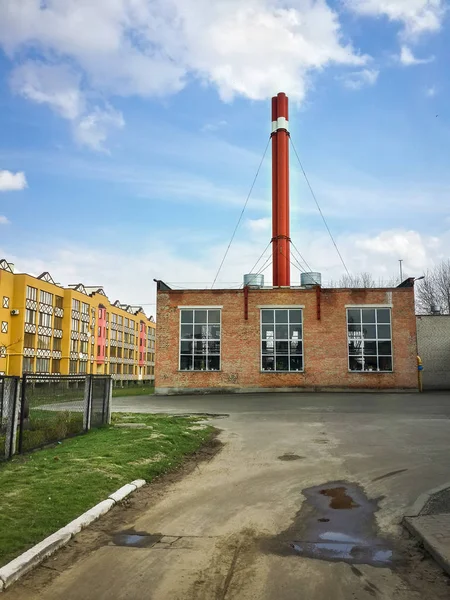 Road to the boiler house surrounded by residential buildings and blue sky