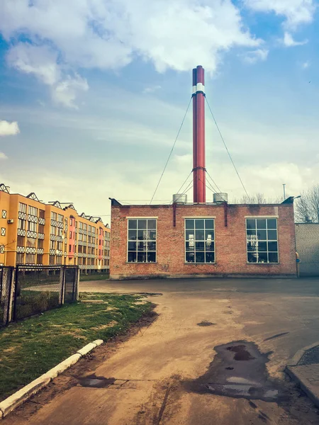 Road to the boiler house surrounded by residential buildings and blue sky