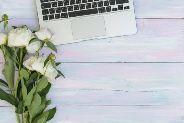 Peonies ve bir ahşap arka plan üstünde laptop. Doku. Sosyal ağlar için fotoğraf